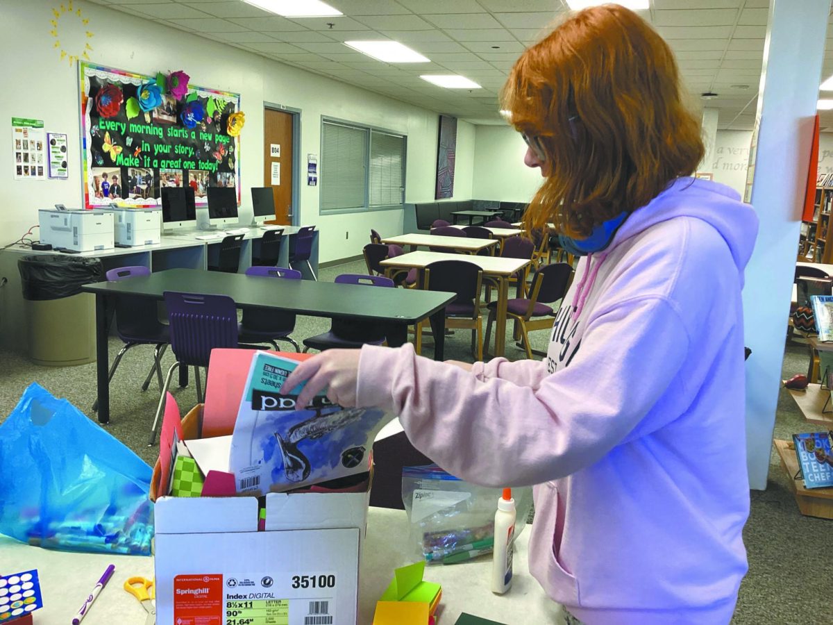 Snip. Snip. Snip. Scissors cut through paper as Key Club President  Addison Pithan works on holiday cards during their club meeting [Left]. Key Club is a club geared towards volunteering, and their next big project will be the Angel Tree, pictured right. “Here is this opportunity if you have the resources to donate. This goes back to  the kids,” Pithan said.
