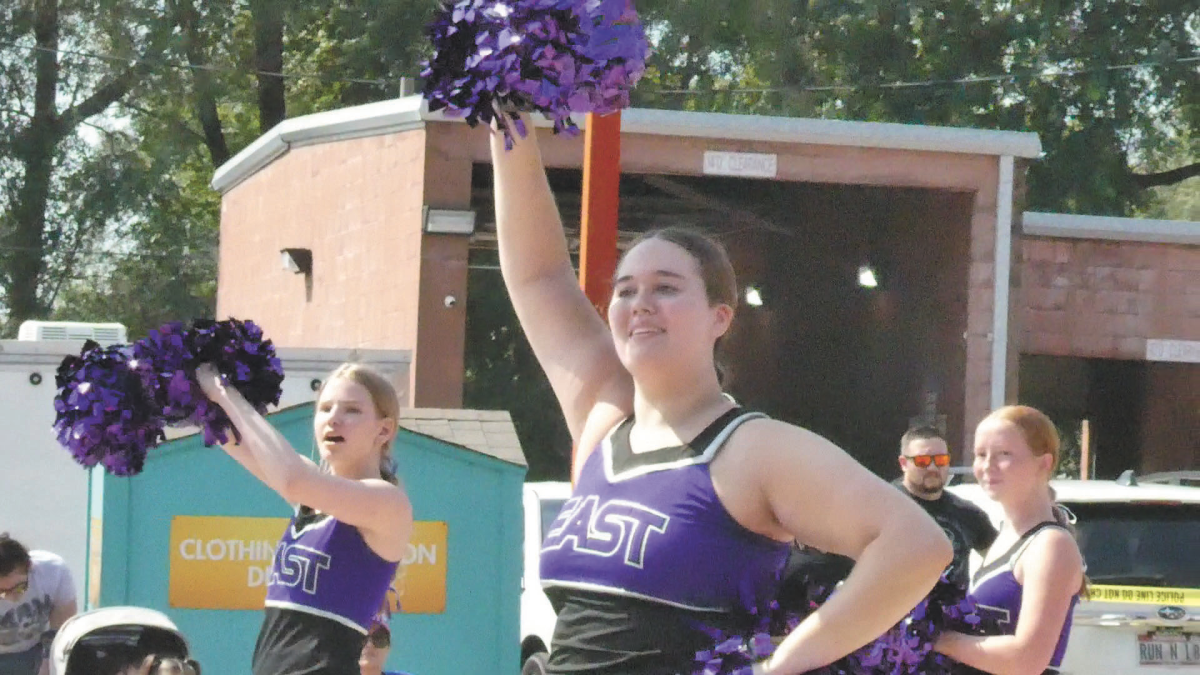 Smile and wave. On August 17, senior Lindsey Burt walks in the Arrows to the Aerospace parade along with the rest of the Bellevedettes. The parade helps local businesses promote themselves and allows for schools to show off their spirit. “[I like] getting to represent the school and the dance team,” Burt said. “To be able to show what we can do.” 