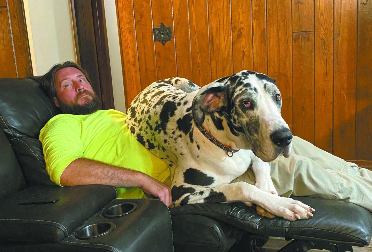 Big heart and big dog. Ric Connell and his dog, Buck, cuddle together on the couch July 7, 2022. Connell gives words of wisdom to his anxious teenagers. “I know my children have a ton of potential, helping them find the key to unlock it is sometimes the hardest part,” Connell said. 