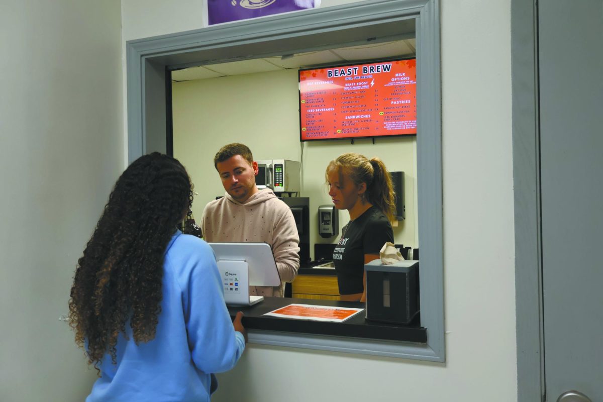Order up. While working the register at the Beast Brew, senior Trinity Marr and FBLA adviser Mitchell Fischer prepare a customer's order by looking at their online order. With the new remodel and Beast Brew location, many FBLA members are eager to see how much money they can raise for FBLA trips. “All of the money that we made, we reinvested it into the coffee shop to grow it to make even more money to provide even more benefits to the student body,” Fischer said.