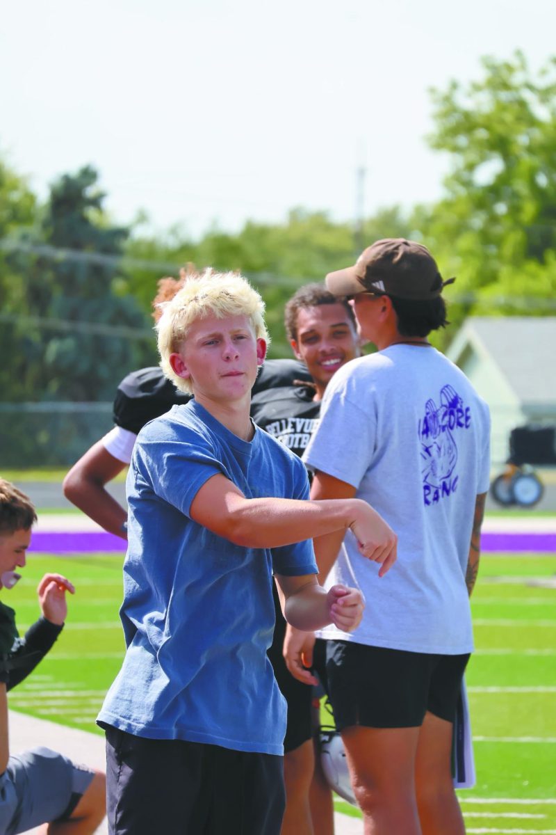 Warmup time.  On August 28, 2025, junior Liam Dworak attends his daily football practice despite being injured on the Bellevue East high school field. Dworak watches the practice to help and also learn. “I was warming up with one of my teammates before he went on the field,” Dworak said.