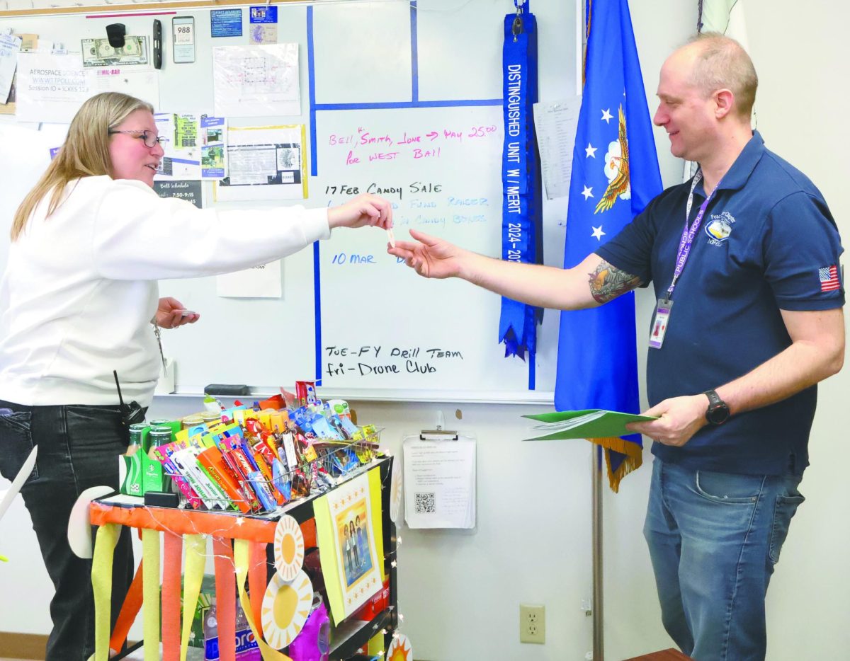A bit of sunshine. In advisory on Friday, February 27, instructor Brian Yates receives a Sunshine Crew sticker from assistant principal Susan Jensen. The Sunshine Crew honors a group of staff members each week and brings the Sunshine Cart on Friday for the appreciated members to choose a snack. “Everybody gets burnt out, especially this time of year,” Yates said. “It’s hard, so I think showing that appreciation, that we all are in the fight together, while working together means a lot and gives us an extra bit of morale and happiness.”