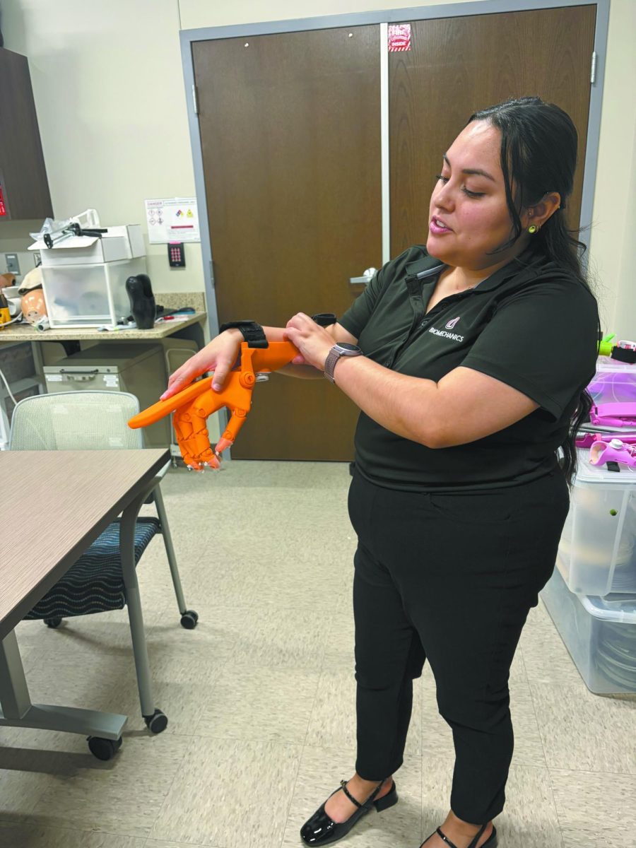 3D magic. Holding a mock prosthetic arm, Ph.D. student Liliana Delgado demonstrates what it’s like to use a prosthetic. The UNO Biomechanics Lab had an open house on Friday, April 17, and many of the labs and their works were on display. “The primary purpose is to 3D print prosthetics for children with limb loss,” Delgado said. “The reason that we do this is because traditional prosthetics are really, really expensive.”